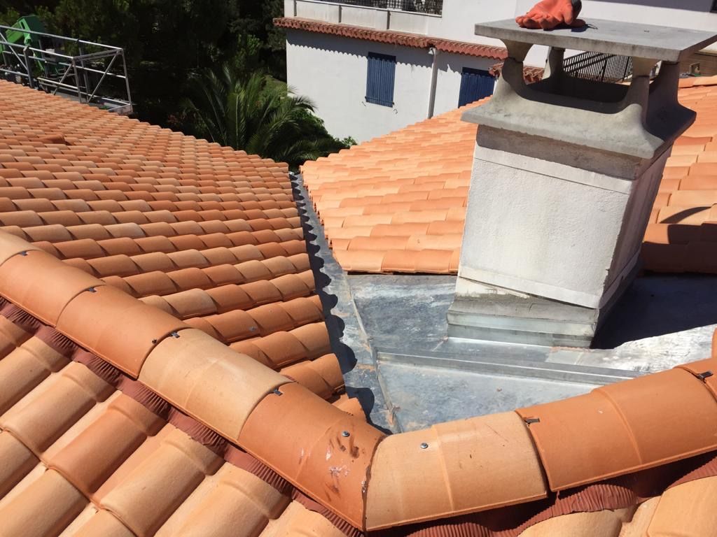 Solin en zinc autour d'une souche de cheminée et faîtage en tuiles