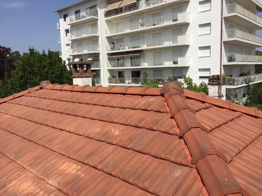 Toiture en tuiles à quatre pans, immeuble en arrière-plan