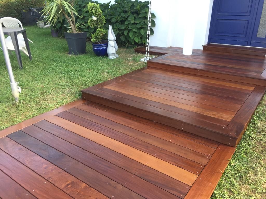 Escalier et paliers en bois devant une porte bleue
